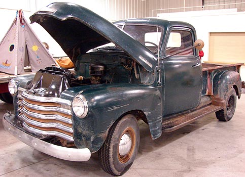 This is a 1950 Chevrolet pickup In the background is a niftily kitschy 